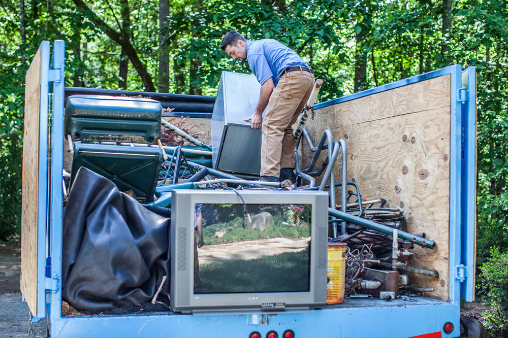 guy putting junk inside truck